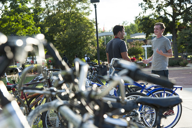 2 students talking near bicycles