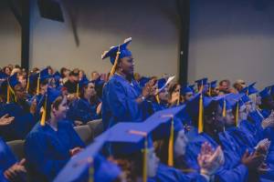 ABE Students attending graduation - a young woman is standing and clapping