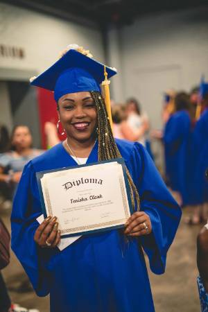 An ABE graduate shows off her diploma