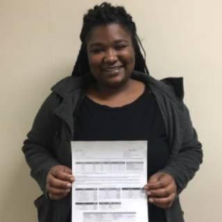 ABE Student SyBriah Roberson posing with her exam results