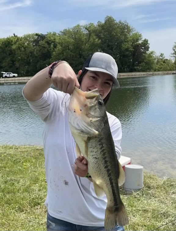 A student holding a large bass