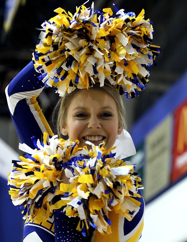 A cheerleader holding a pair of pom poms