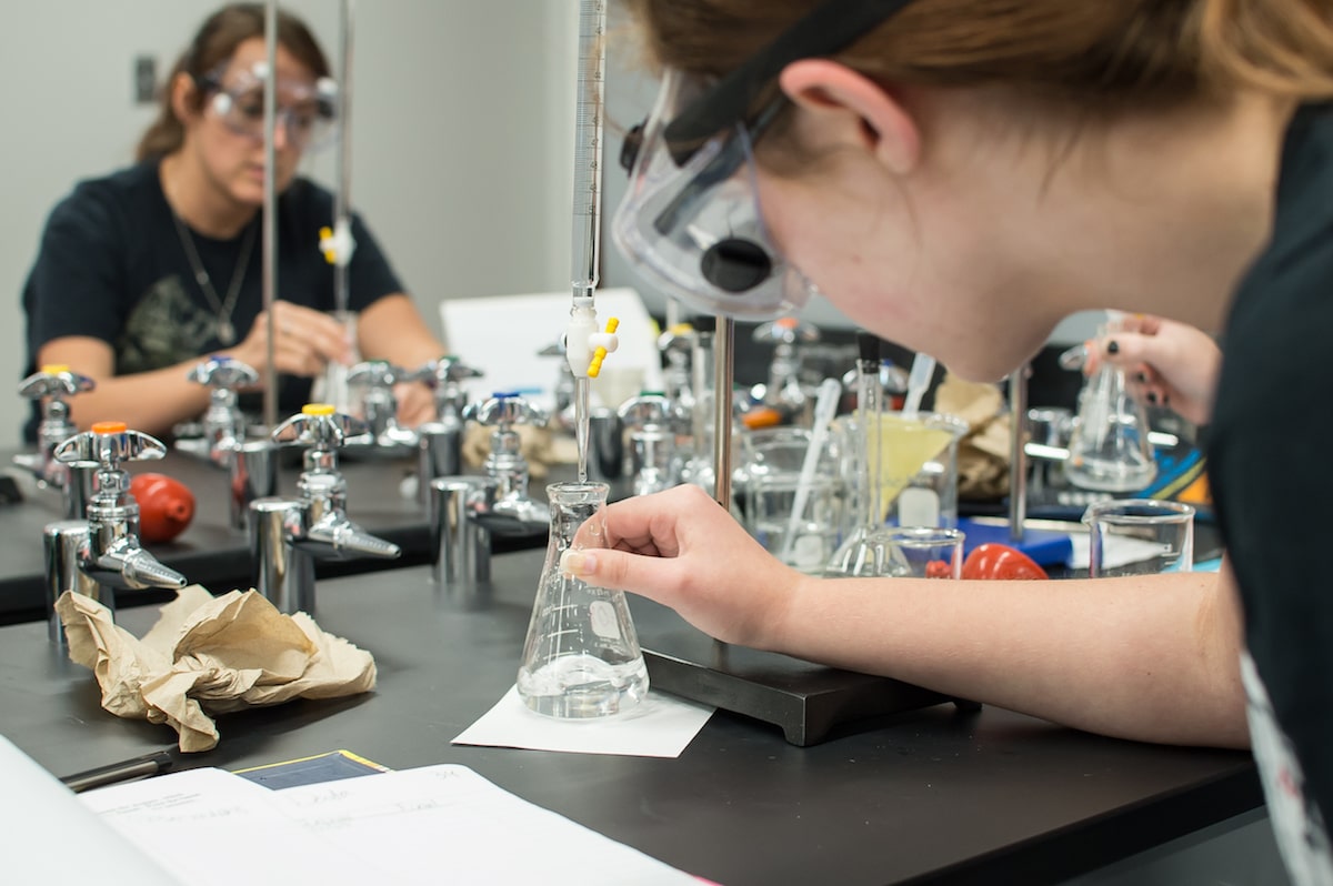 A chemistry student filling up a flask with water