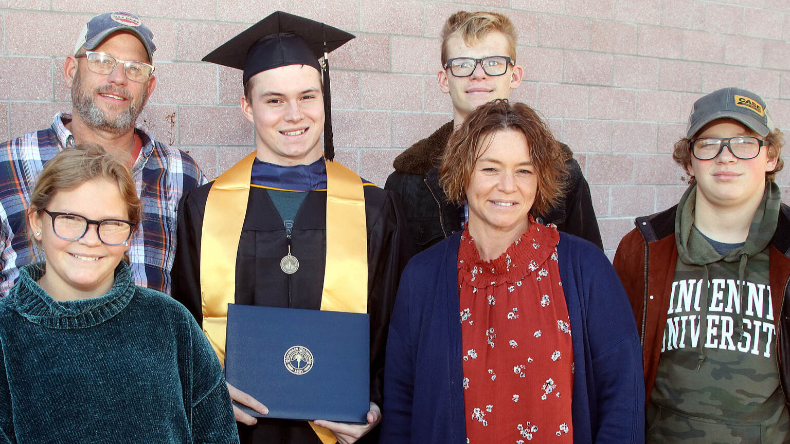 Graduate posing with family in reglia