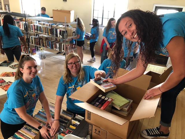 Day of Caring volunteers putting old books into boxes