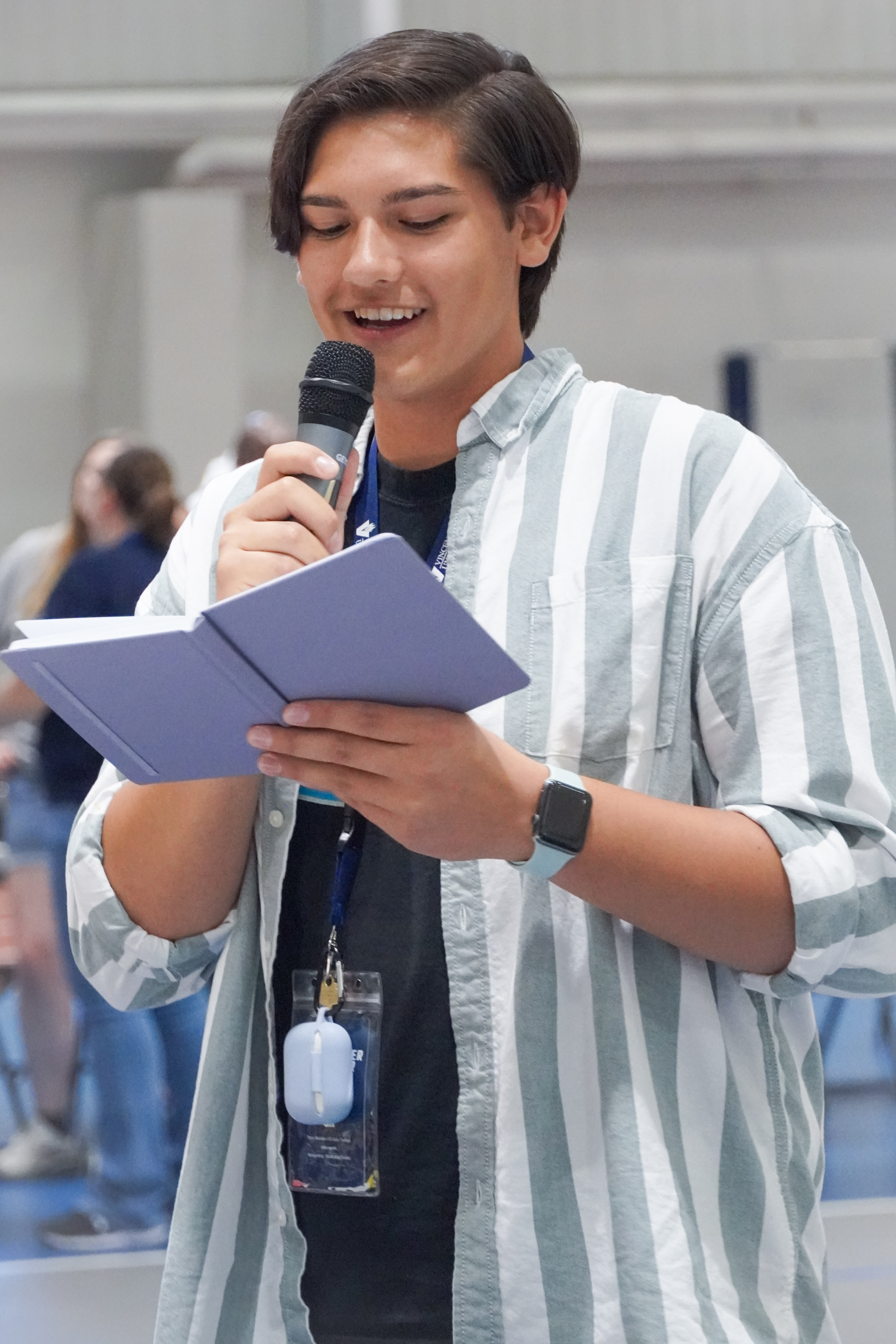 Young latino man speaking at a microphone