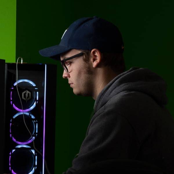 A male student using on of the computers in the arcade