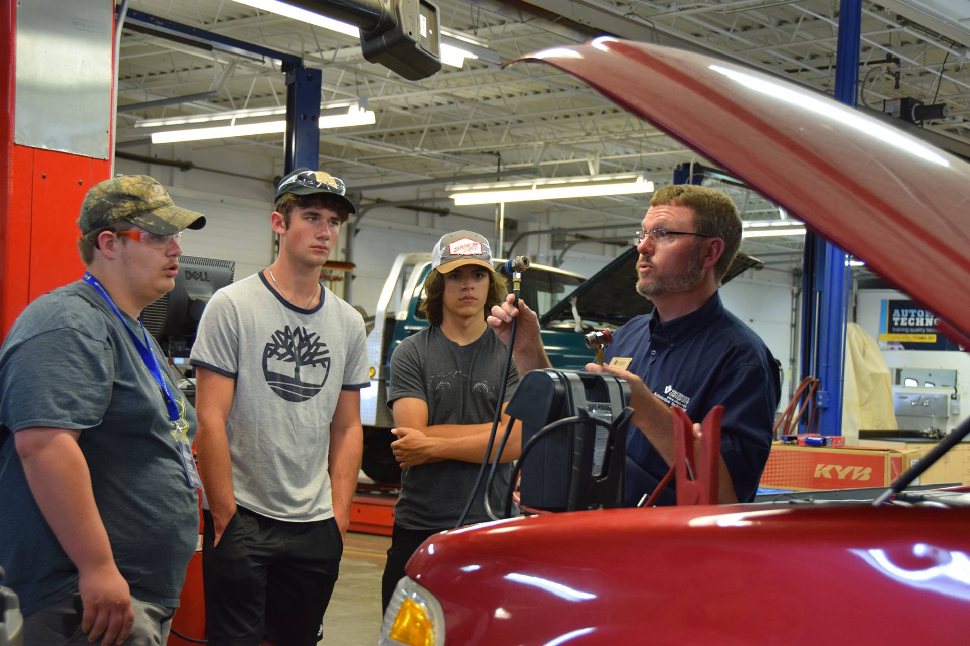 Automotive club students meet with their instructor