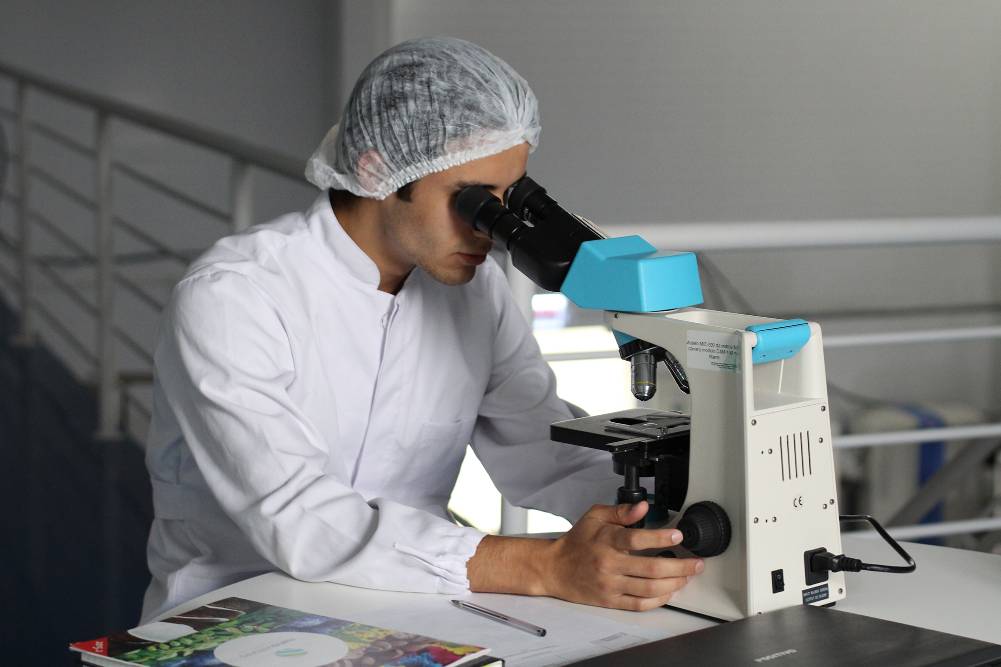 A scientist examining something under a microscope
