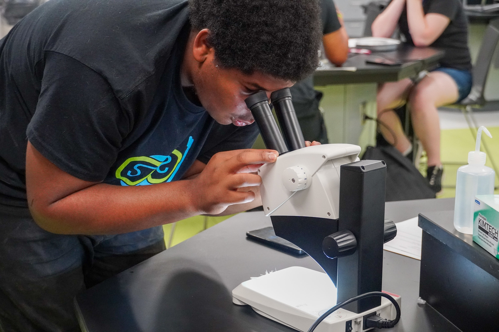 A student looks into a microscope.