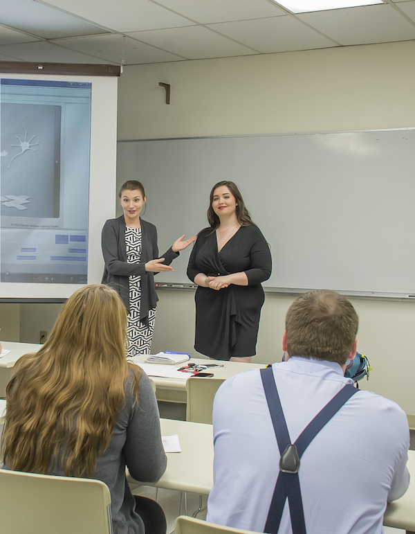 Two students presenting a project in front of their classmates