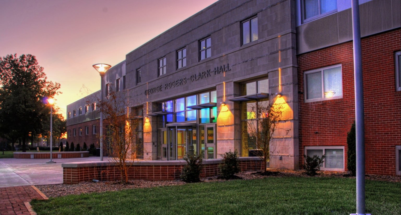 Clark hall at sunset with the deep blue of the night sky reflecting in the front windows