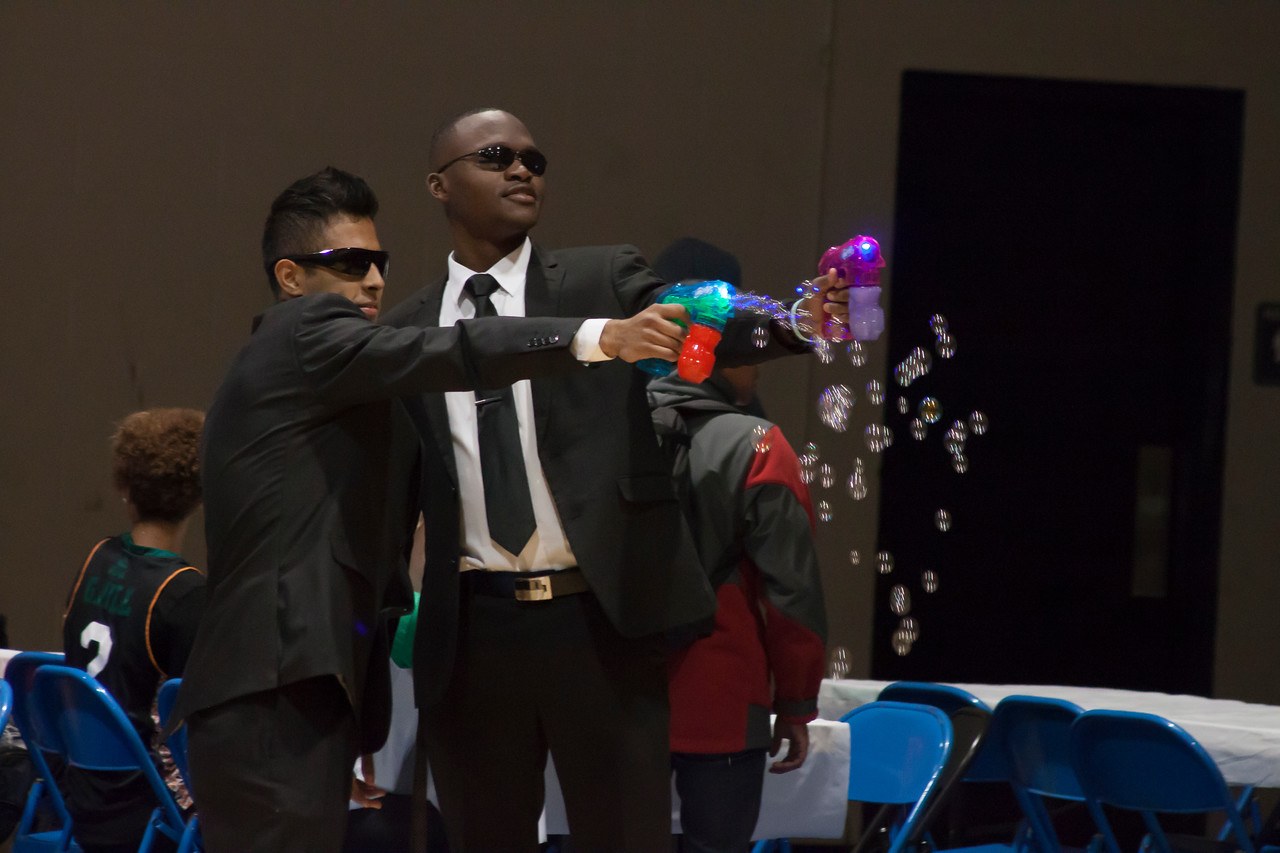 Two students in suits and sunglasses firing bubble guns