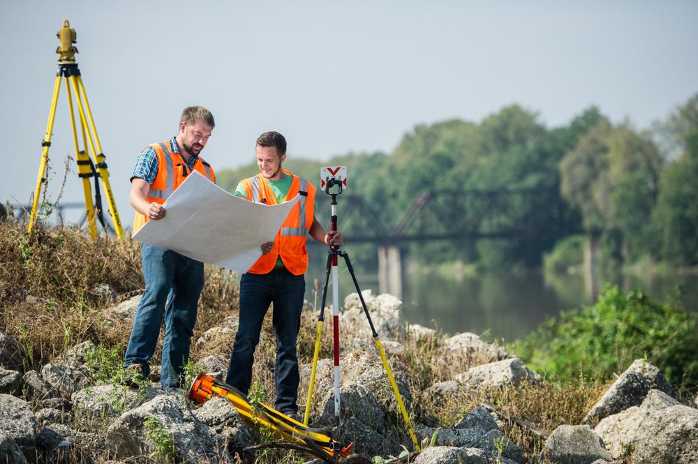 Two surveying professionals looking at blueprints