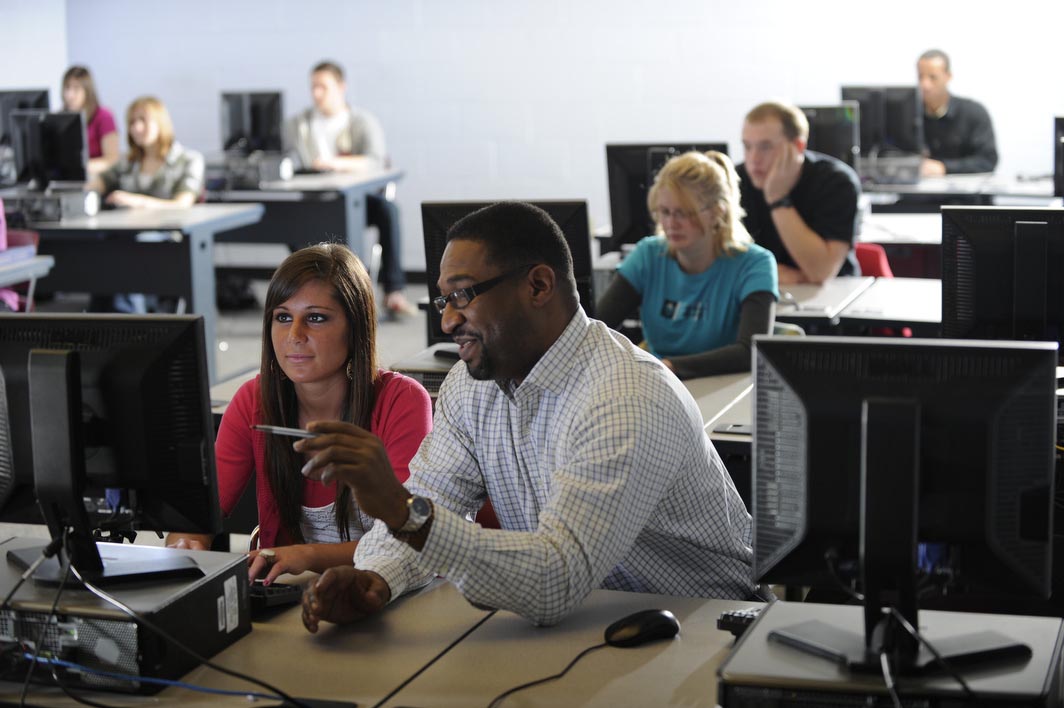 Tyson works with a student at a computer