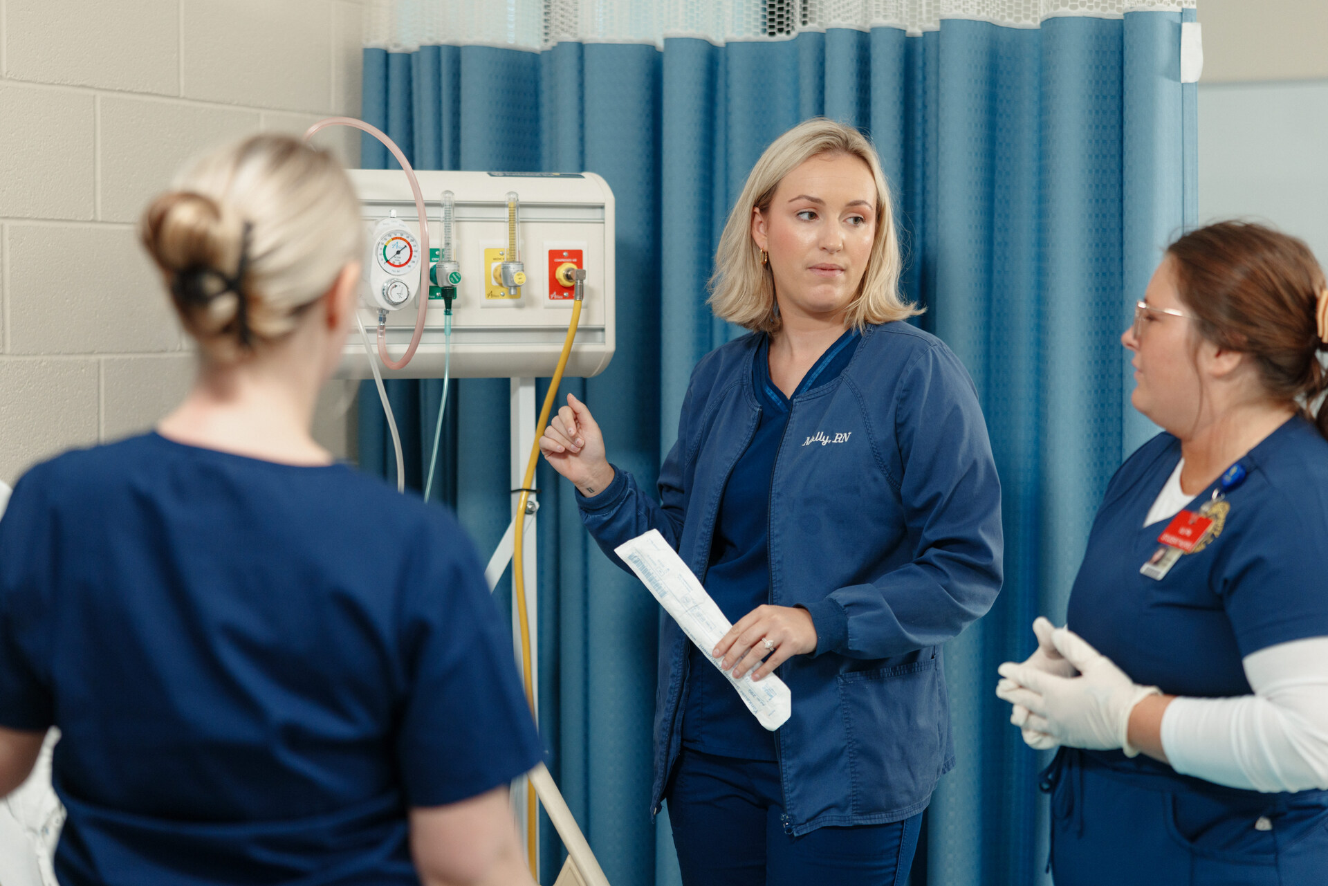Nursing student putting a mask onto a training dummy