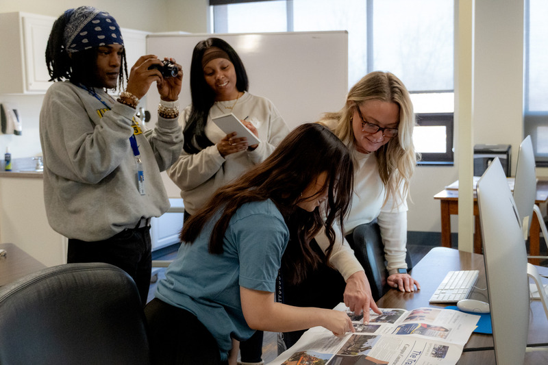 A communications major speaking to two other students