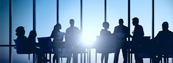 Businessmen and women having a meeting in front of a large window