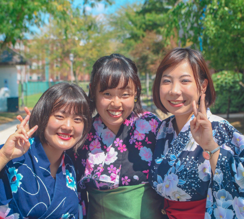 Two Asian women give the V sign for VU when they visited for graduation