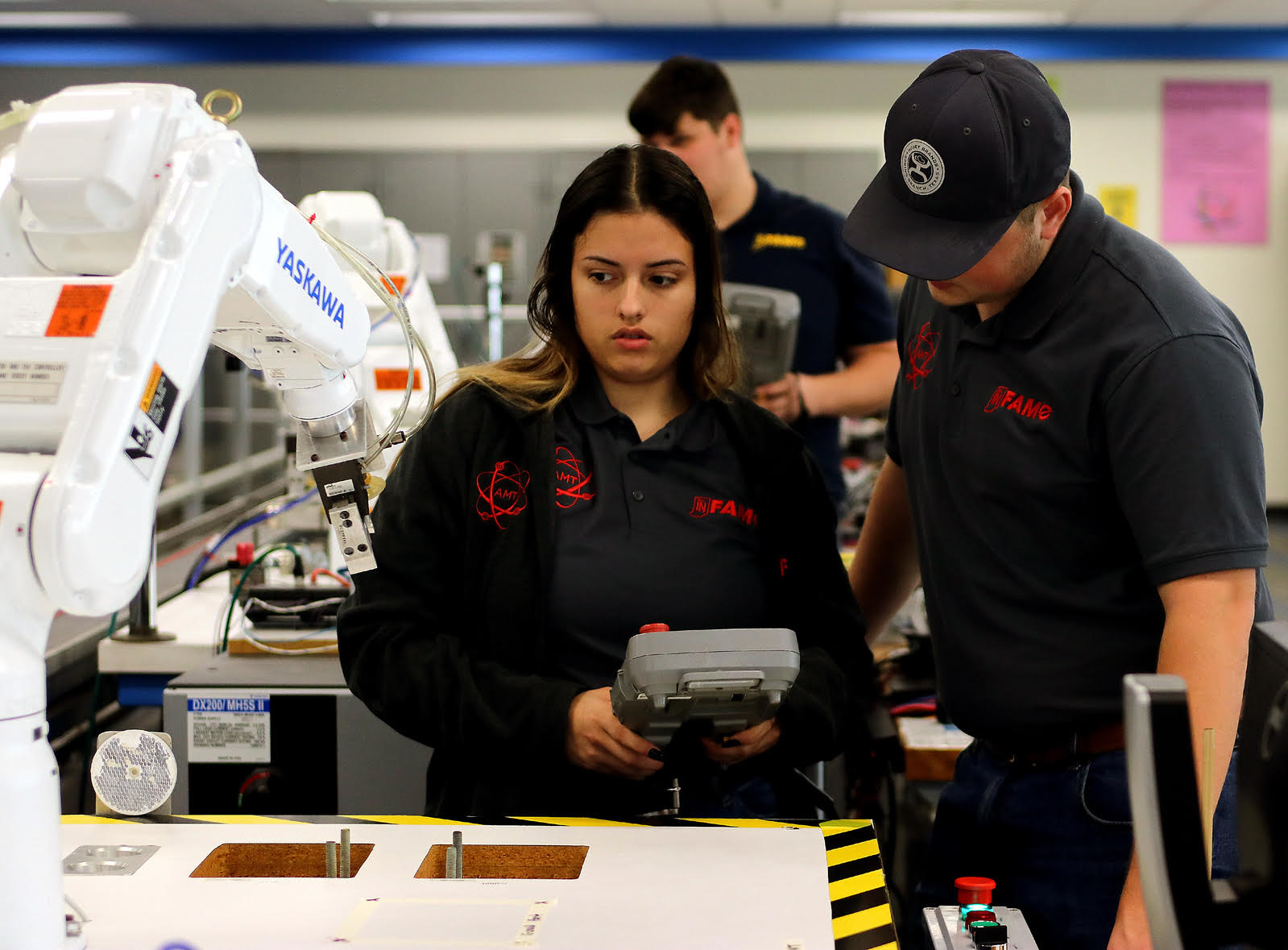 Student and instructor working with a robot arm.